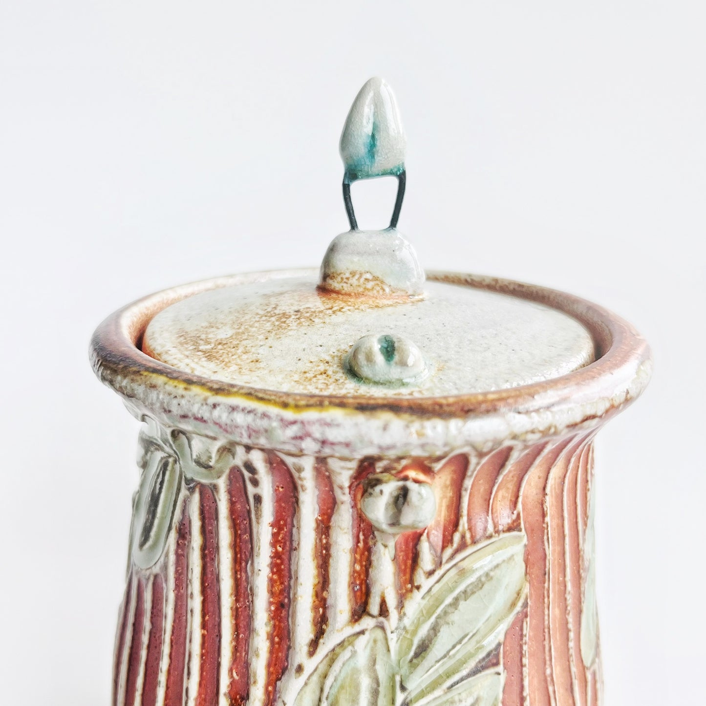 Ceramic jar with decorative lid on a white background