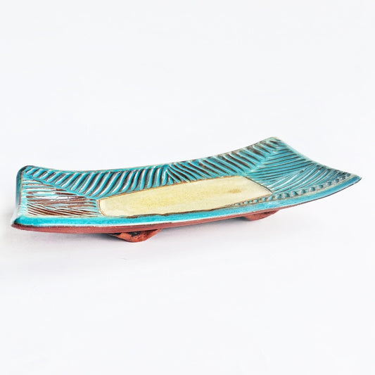 This slab built rectangle dish is great for serving snacks, appetizers, sushi plate, or fun lunch plate! Made from lowfire red earthenware clay, the hand carved turquoise and yellow glaze makes a beautiful statement contrasting with the red clay.