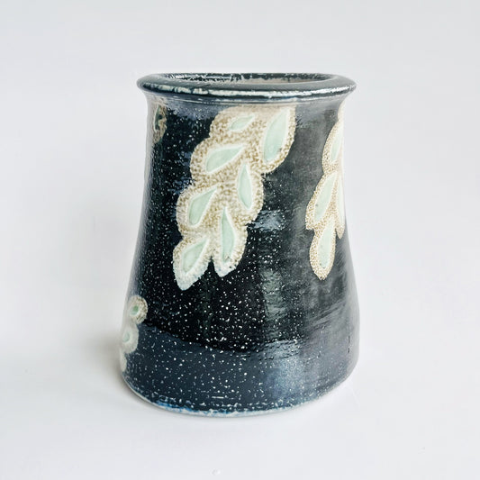 Black flower vase with white and green leaf pattern