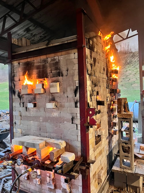 A kiln with flames spilling out of the bricks