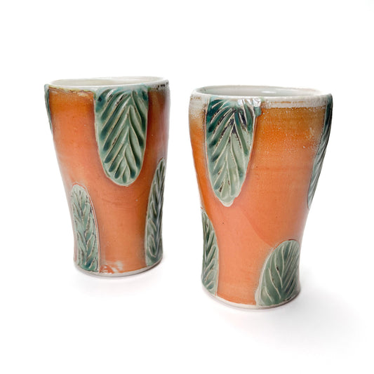 Handmade wheel thrown porcelain tall cups, can also be used as flower vases. Hand carved green leaf pattern around sides of the cup