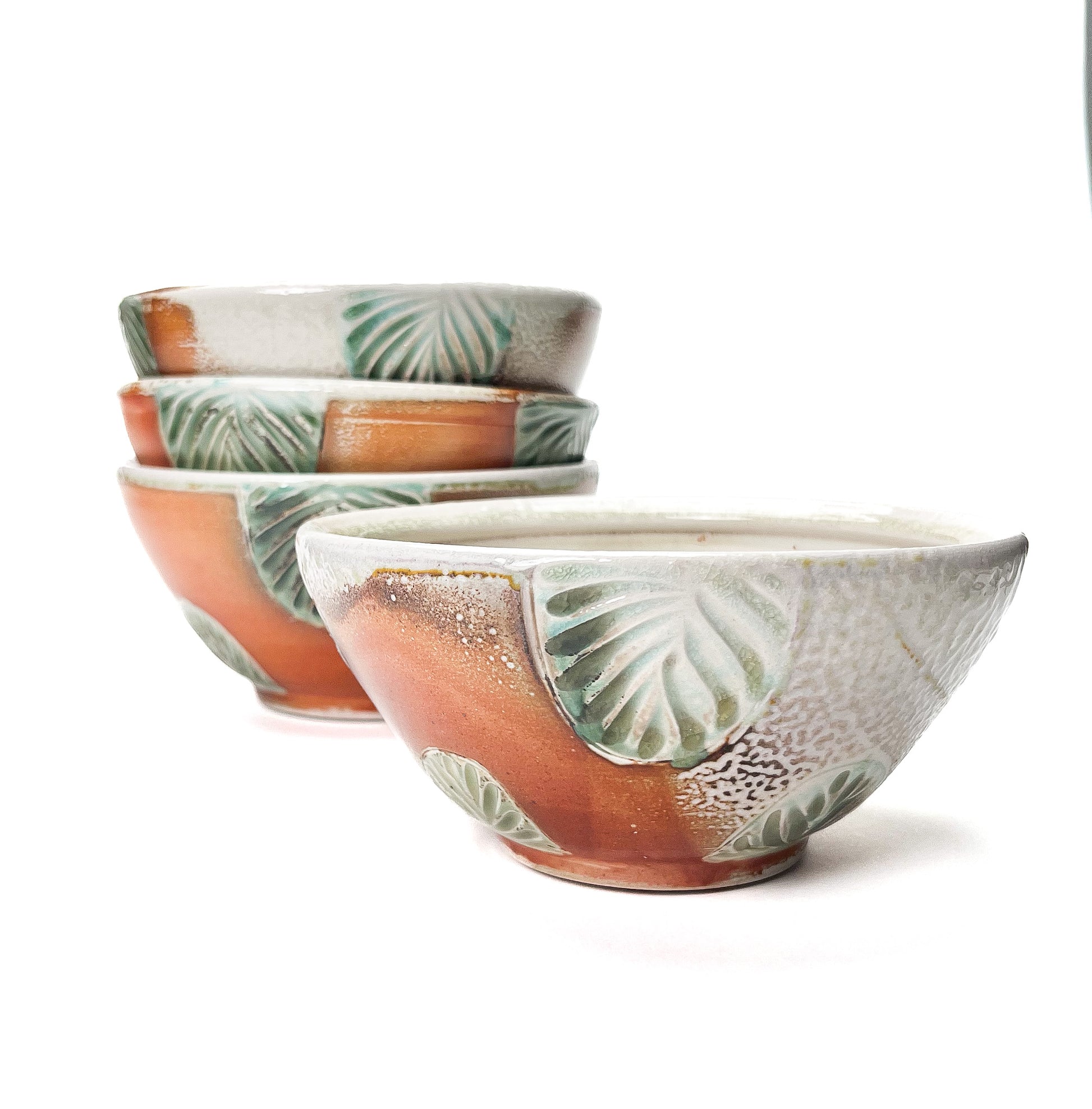 This bowl is a great size for cereal, soup or salad. The hand carved green leaf pattern is inspired by nature. The rest of the piece is varied earth tones, with a interior white glaze.