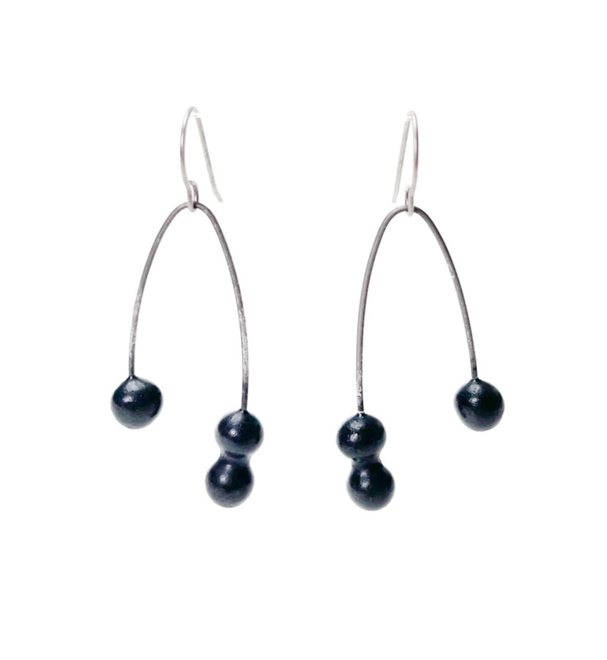 Black handmade earrings that resemble seeds. Hypoallergenic ear wires