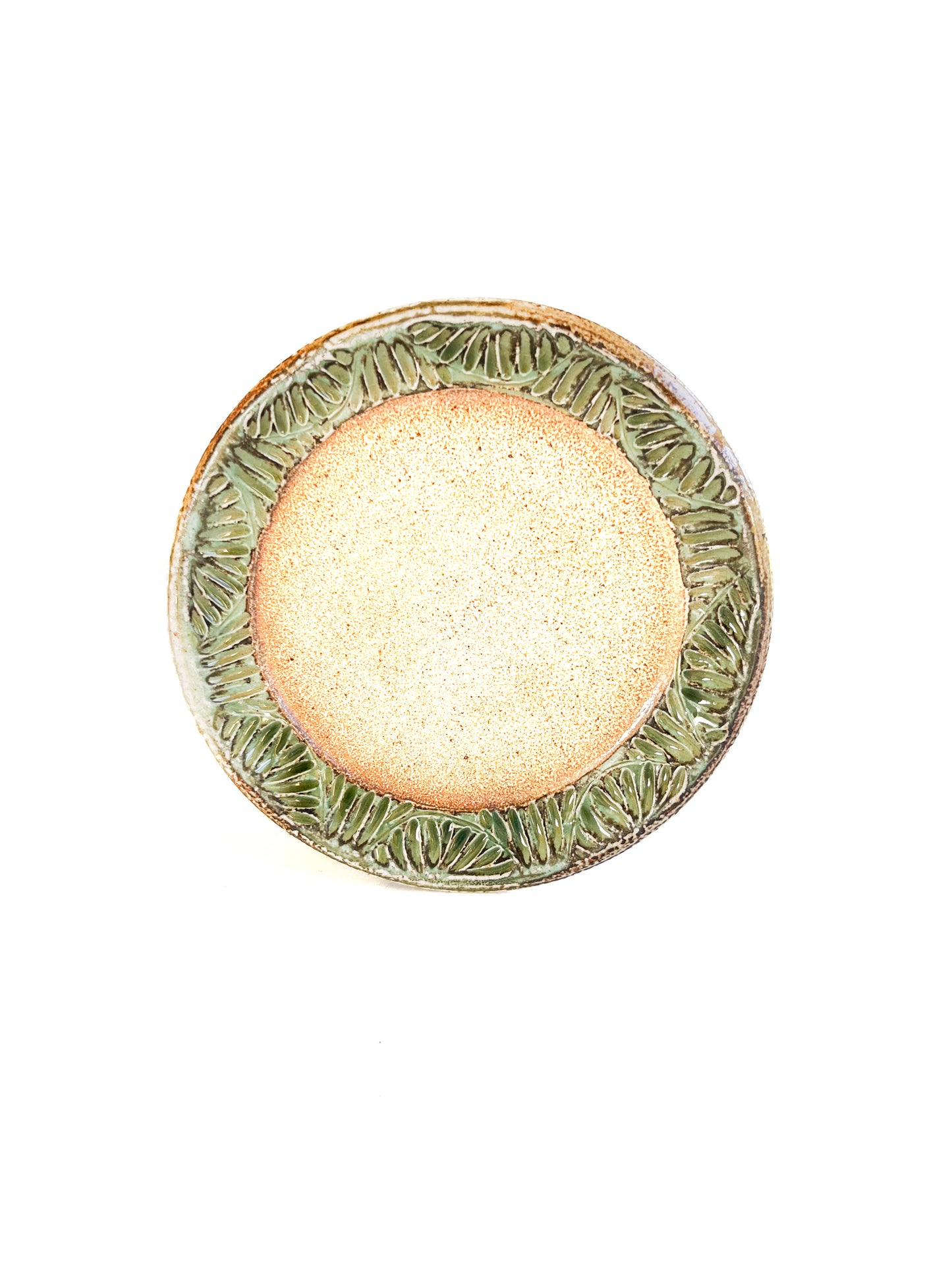 A handmade plate makes your food taste better. This plate is wheel thrown from stoneware clay. The leaf pattern that is hand carved is inspired by nature. The rim of the plate is green and the rest of the plate is earth toned.