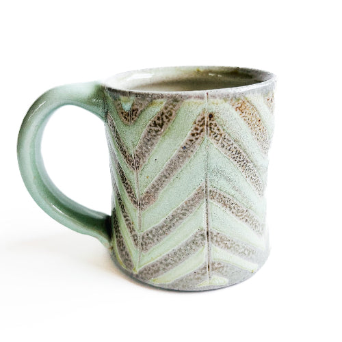 pale green handmade pottery mug with striped pattern