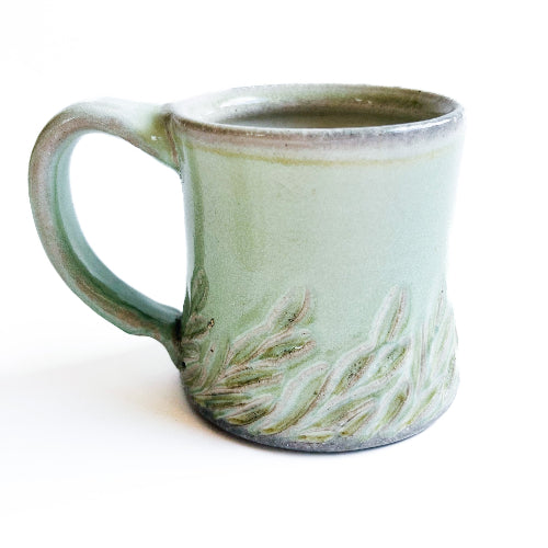 pale green handmade pottery mug with handcarved texture
