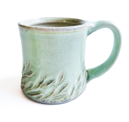 pale green handmade pottery mug with handcarved texture