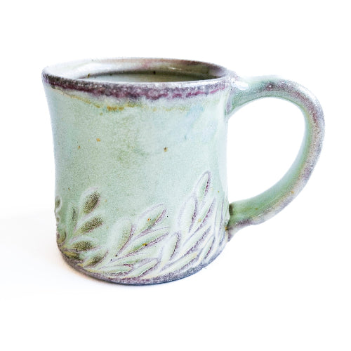 pale green handmade pottery mug with handcarved texture