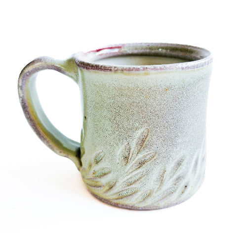 pale green handmade pottery mug with handcarved texture