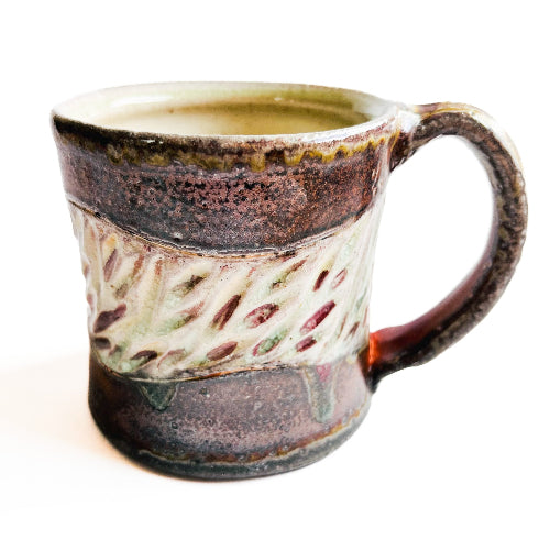 earth toned handmade pottery mug with handcarved texture