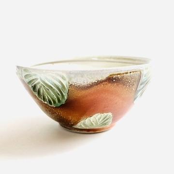 This bowl is a great size for cereal, soup or salad. The hand carved green leaf pattern is inspired by nature. The rest of the piece is varied earth tones, with a interior white glaze.