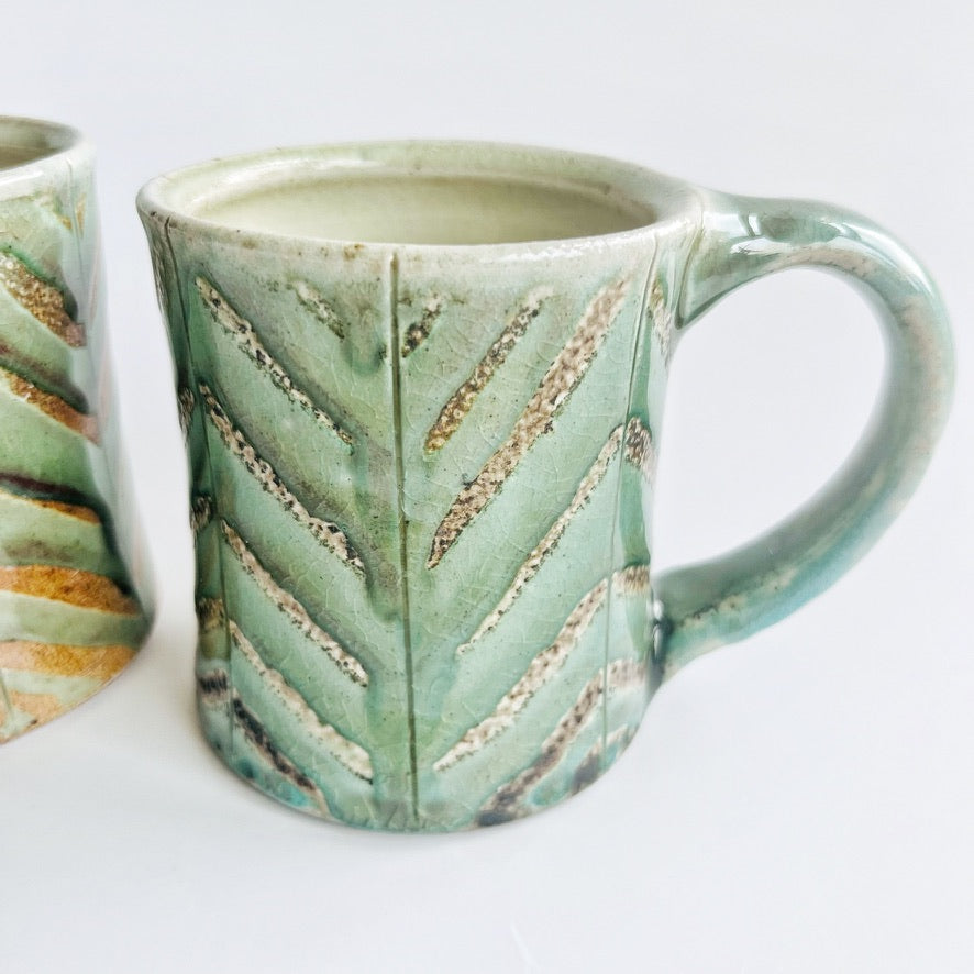 Pale green patterned pottery mug