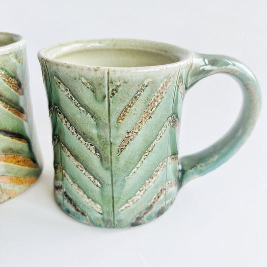 Pale green patterned pottery mug