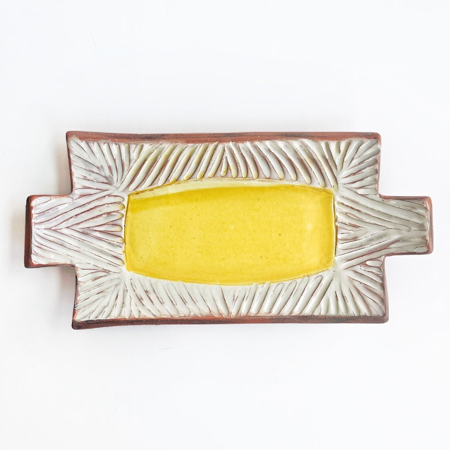 This slab built rectangle dish is great for serving snacks, appetizers, sushi plate, or fun lunch plate! Made from lowfire red earthenware clay, the hand carved white pattern and yellow glaze makes a beautiful statement contrasting with the red clay.