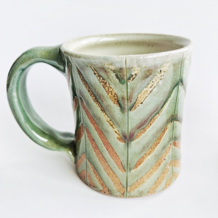 Pale green patterned pottery mug