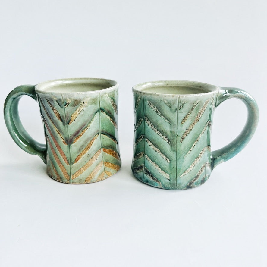 Pale green patterned pottery mug