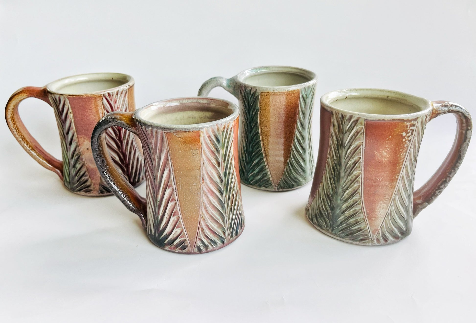 Handmade and carved pottery mug in earth tones