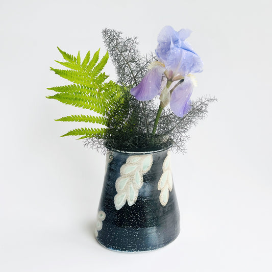 Black flower vase with white and green leaf pattern