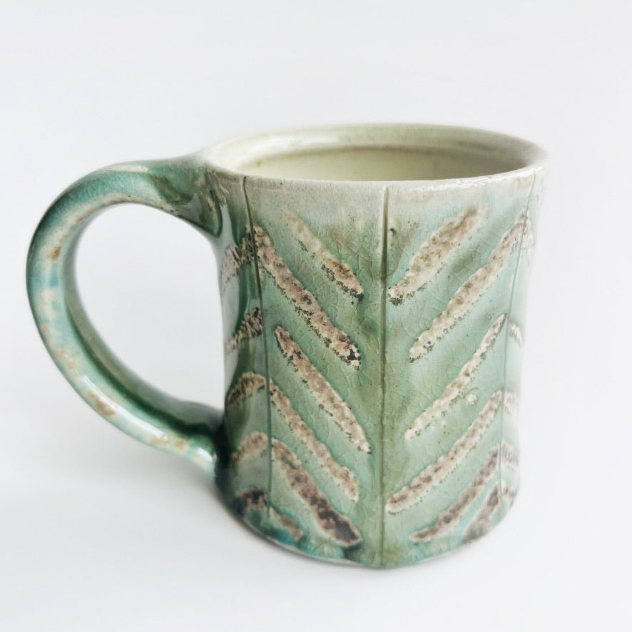 Pale green patterned pottery mug