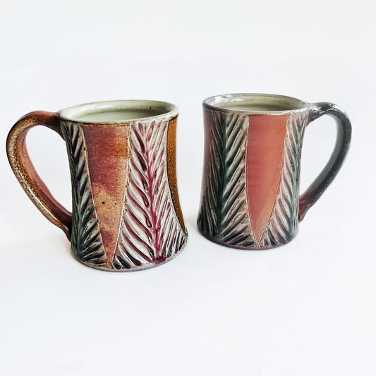 Handmade and carved pottery mug in earth tones
