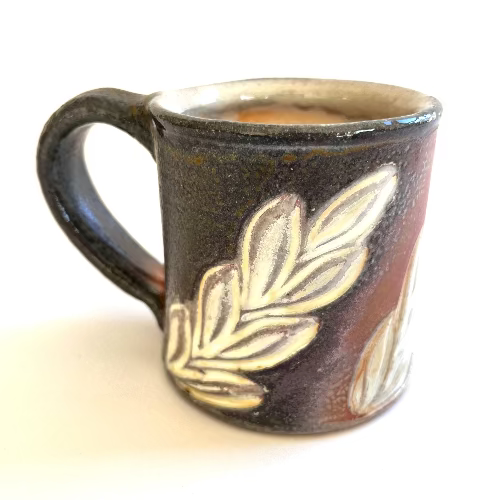 Ceramic mug with leaf design on a white background