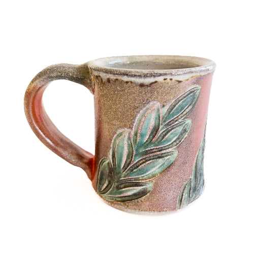 Ceramic mug with leaf design on a white background