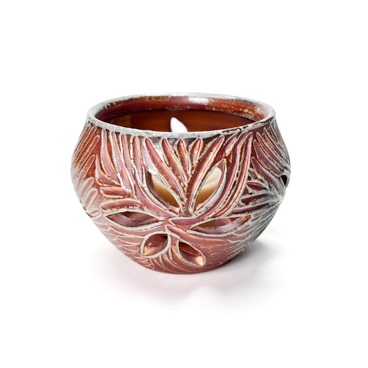 A carved candle holder that shines light out through the pierced holes on the sides when the candle is lit.