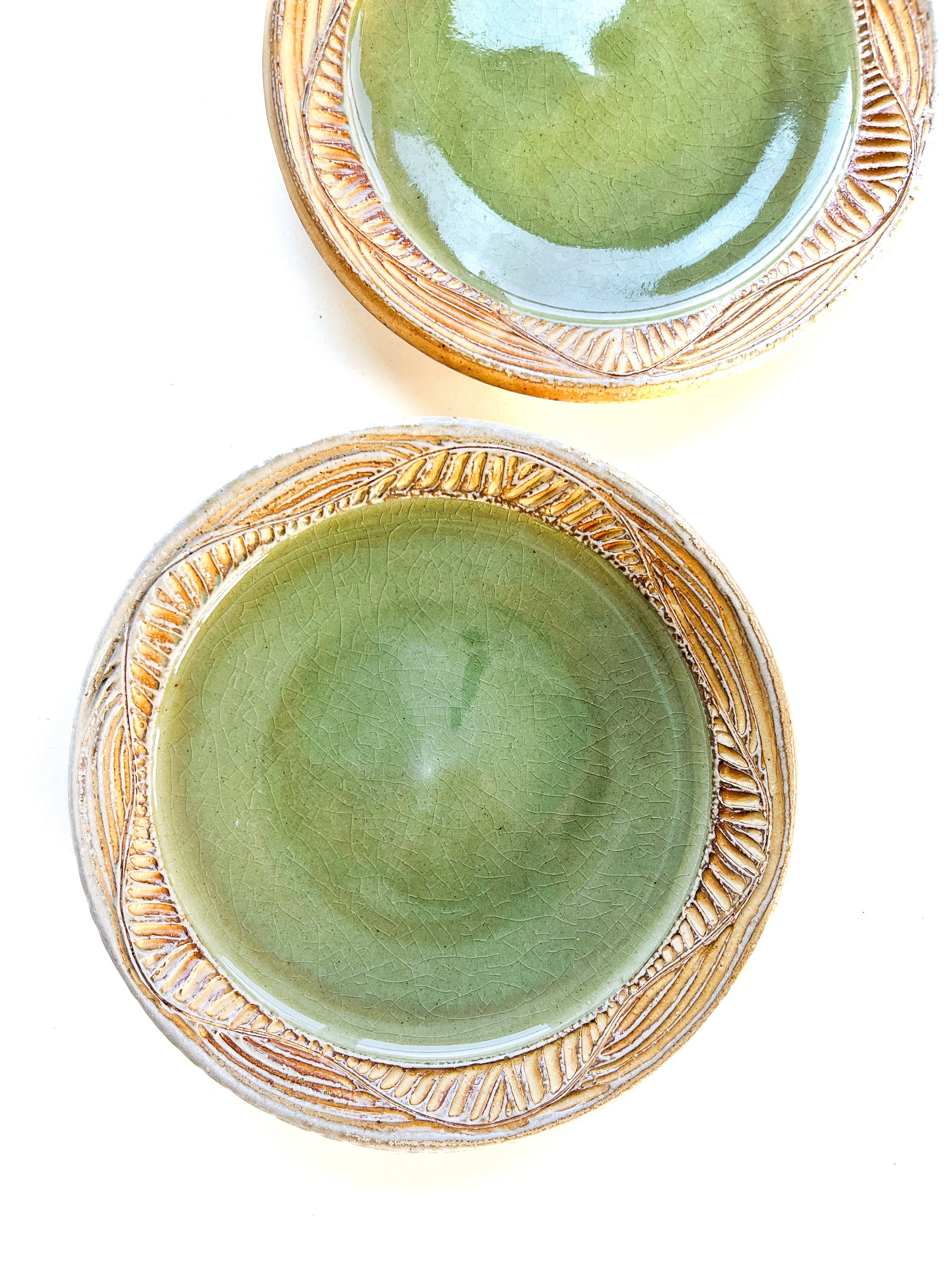 A handmade plate makes your food taste better. This plate is wheel thrown from stoneware clay. The leaf pattern that is hand carved is inspired by nature. The rim is yellow and the interior of the plate is light green.