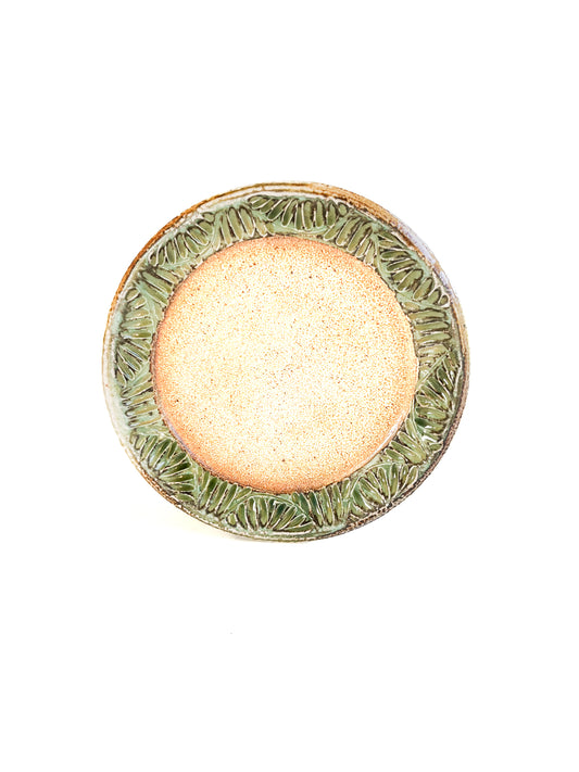 A handmade plate makes your food taste better. This plate is wheel thrown from stoneware clay. The leaf pattern that is hand carved is inspired by nature. The rim of the plate is green and the rest of the plate is earth toned.