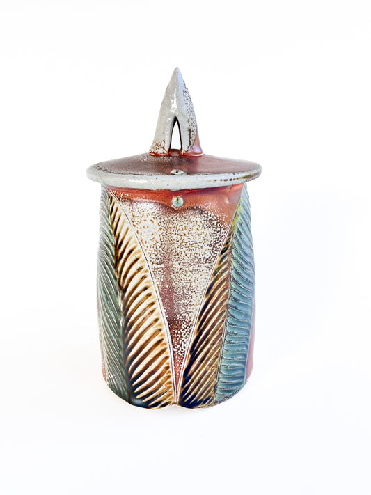 This medium sized handmade jar could be used to store coffee, tea bags, sugar, or candy. The leaf pattern that is hand carved is inspired by nature. 