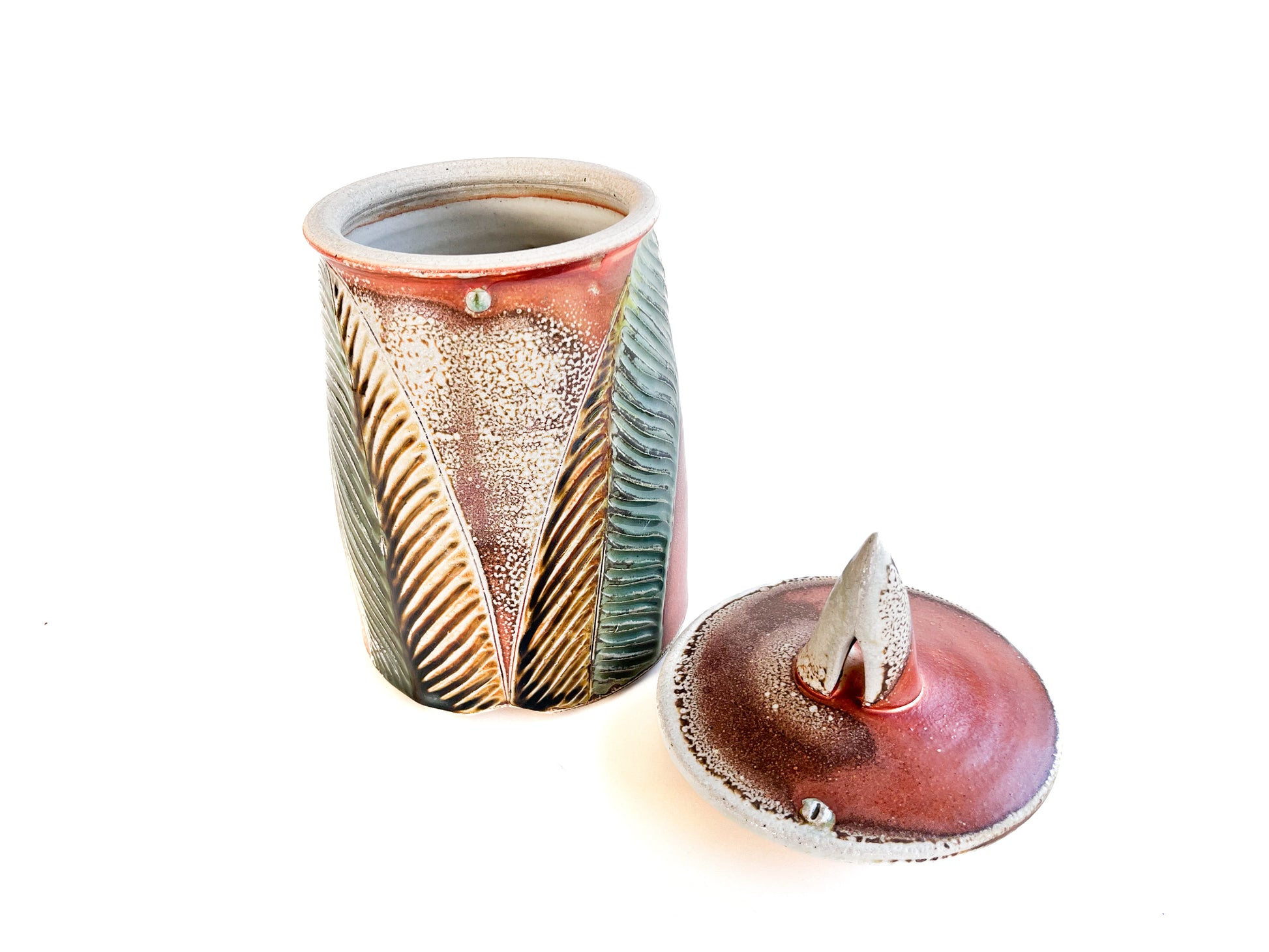 This medium sized handmade jar could be used to store coffee, tea bags, sugar, or candy. The leaf pattern that is hand carved is inspired by nature. 