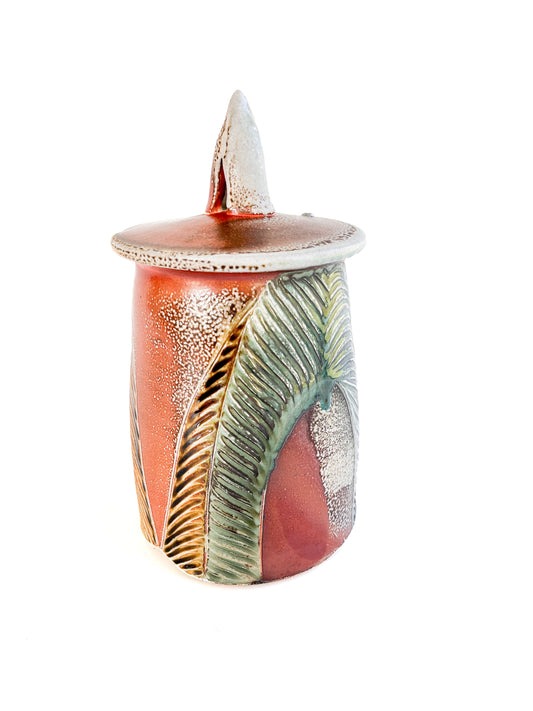 This medium sized handmade jar could be used to store coffee, tea bags, sugar, or candy. The leaf pattern that is hand carved is inspired by nature. 