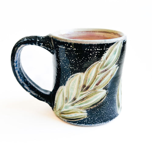Black starry night handmade pottery mug with green leaves