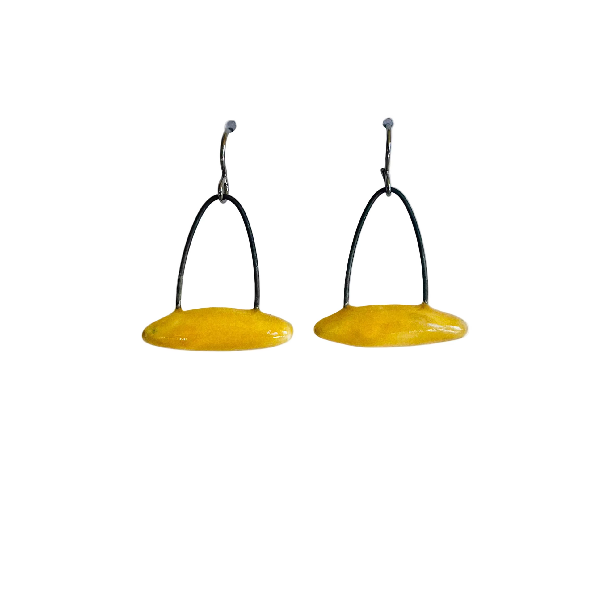 Pair of yellow earrings with black wires on a white background