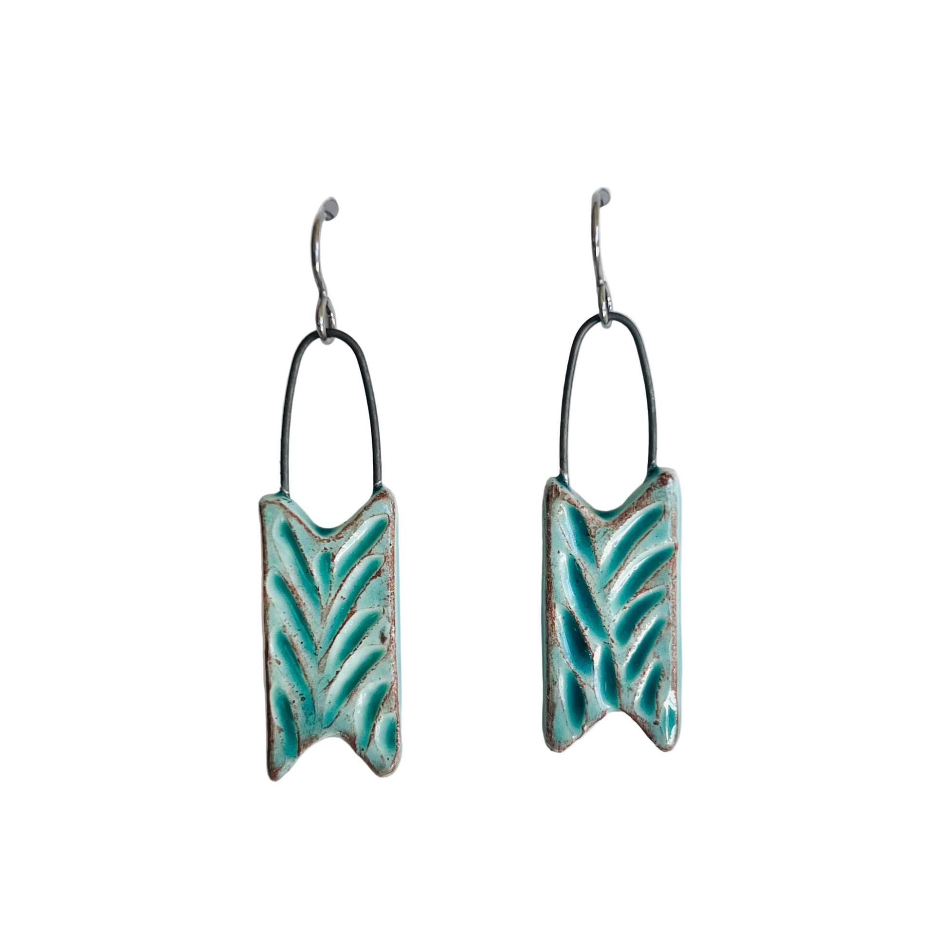 Pair of turquoise leaf-patterned earrings on a white background
