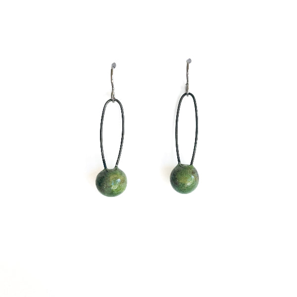 Pair of earrings with green spherical beads on black strings against a white background