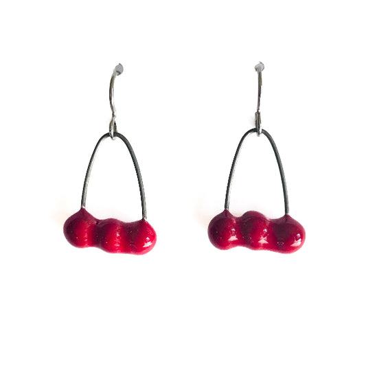 Red cherry-shaped earrings on a white background