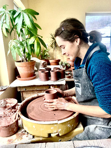 Joy Tanner throwing a clay pot at a potter wheel